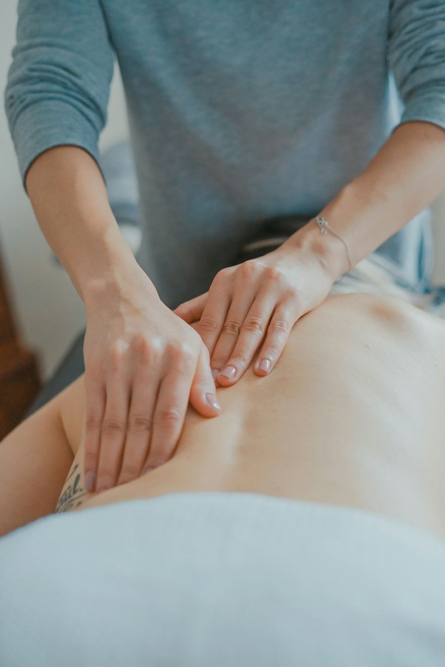 Mains d'une thérapeute appliquant une pression ciblée sur le bas du dos